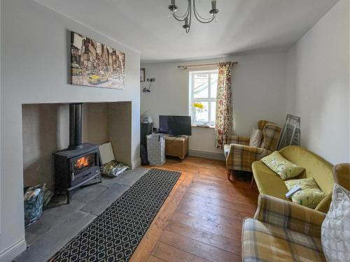 a living room with a fireplace and a couch at Fronfanol - Uk49776 in Llanfair Talhaiarn