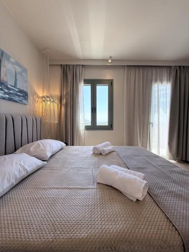 a large bed with two towels on top of it at Monte Vista Lemnos Apartments in Myrina