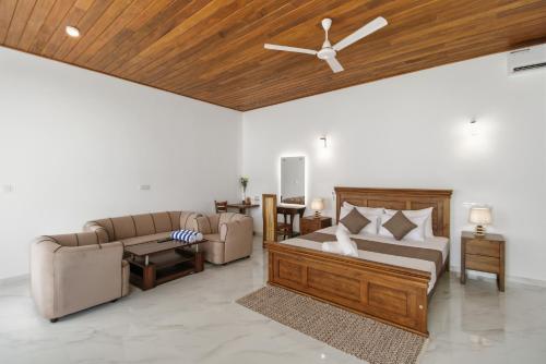 a living room with two couches and a wooden ceiling at Mihira Gedara Apartments in Unawatuna