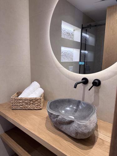 a bathroom with a stone sink and a mirror at Monte Vista Lemnos Apartments in Myrina