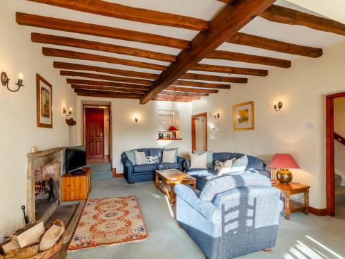 a living room with blue couches and a fireplace at Griff Head Cottage in Carlton