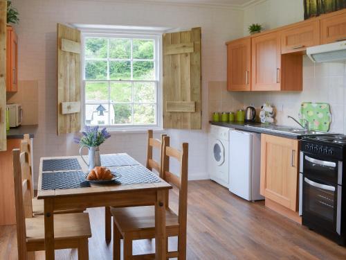 a kitchen with a table and chairs and a sink and stove at Gibson Apt- Cv11 in Liskeard