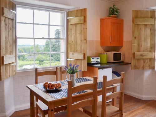 a kitchen with a table and chairs and a window at Gibson Apt- Cv11 in Liskeard