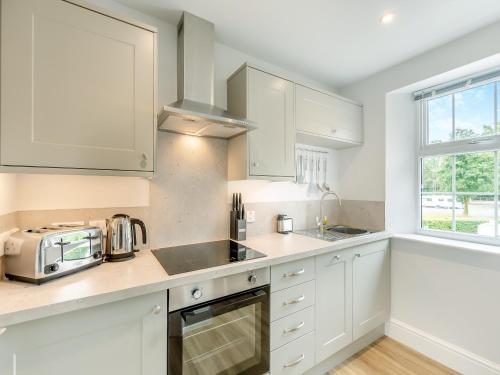a kitchen with white cabinets and a sink and a microwave at Baycliff Apartment in Lindale