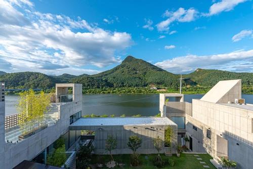 a building with a view of a lake and mountains at Chuncheon Onda Poolvilla in Chuncheon