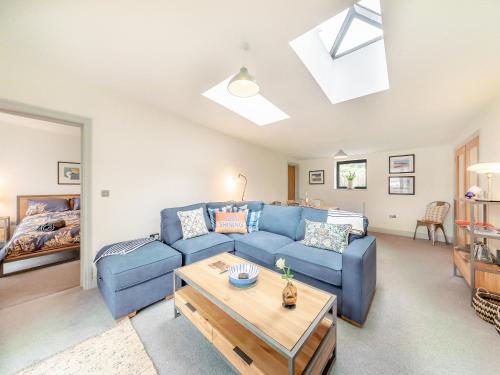 a living room with a blue couch and a table at Number 29 in Alnwick