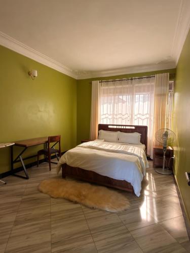 a bedroom with a bed and a desk and a window at Express Living & Wellness in Jinja