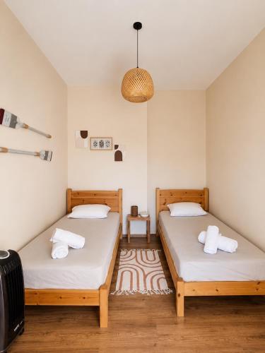 two twin beds in a room with a rug at DeJon Apartment in Gjilek
