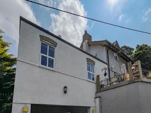 a white building with a balcony on top of it at Fronisaf - Uk49775 in Llanfair Talhaiarn
