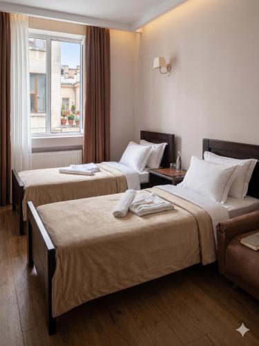 a hotel room with two beds and a window at Guest House Kobuleti 516 in Kobuleti