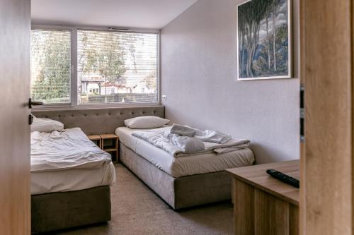 a room with two beds and a window at Imperiall Resort&MediSPA-DOMKI PREMIUM in Sianozety