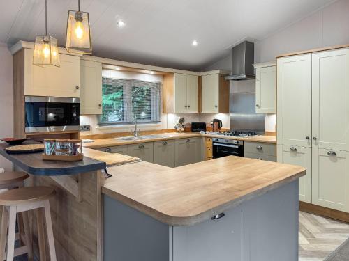 a kitchen with white cabinets and a large island at Portland in Poole