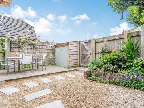 a patio with a table and chairs in a garden at Duck Island Cottage in Ringwood