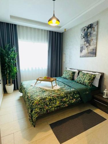 a bedroom with a bed with a table on it at cozy Apartment, Parc Serenity in Mohammedia