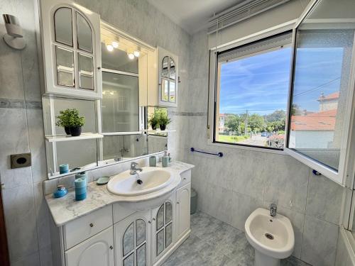 a bathroom with a sink and a toilet and a window at Apartamento Albamar 32802 in Pedreña