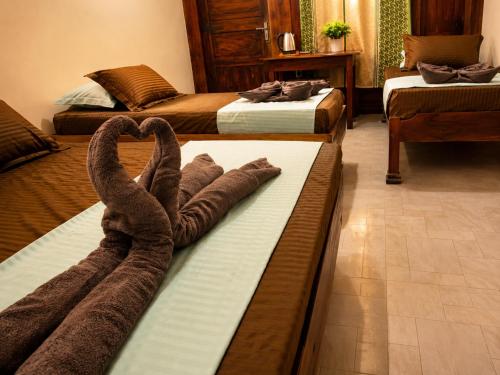 a hotel room with two beds with towels at Leaf Villa in Arugam Bay