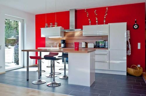 a kitchen with red walls and a counter with stools at Paula in Bitz