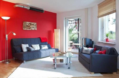 a living room with a blue couch and a red wall at Paula in Bitz