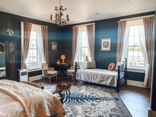 a bedroom with blue walls and a bed and windows at Historic Knox Hotel in Princeton