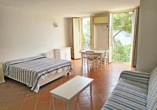 a bedroom with a bed and a table and chairs at Appartamenti Capo d'Arco in Capo D'Arco