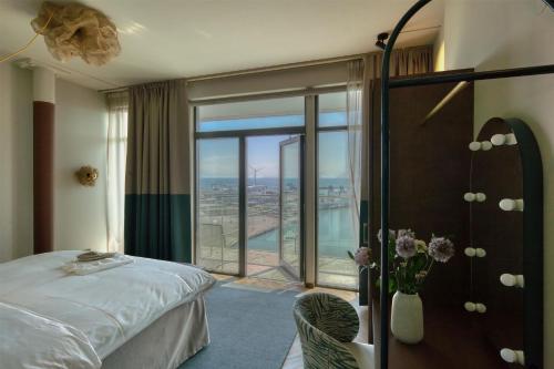 a hotel room with a bed and a large window at Willow, WorldHotels Crafted in Trelleborg