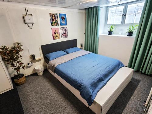 a bedroom with a bed with a blue comforter at The Alpine Studio Hideout in Schwanden