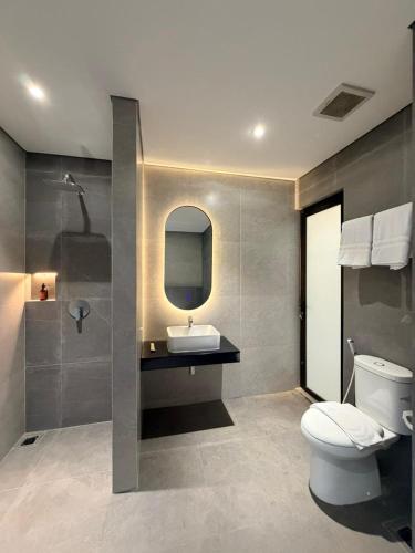 a bathroom with a white toilet and a sink at Grand WK Hotel in Yogyakarta
