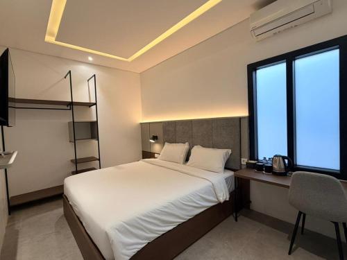 a bedroom with a bed and a desk and a window at Grand WK Hotel in Yogyakarta