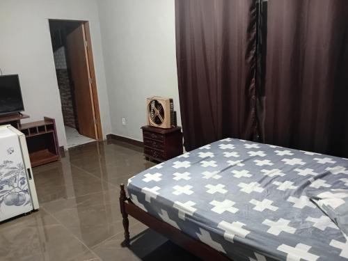 a bedroom with a bed and a television in it at Sitio Daniel in Mateus Leme