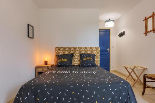 a bedroom with a bed with a blue comforter at Le Lavoir De Gras - Chambre d'hôte in Gras