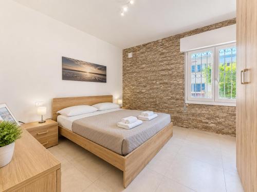 a bedroom with a bed and a brick wall at Villa Gaspare in Lido di Jesolo