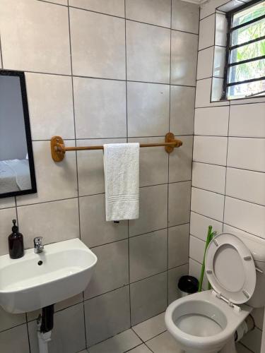 a bathroom with a white toilet and a sink at Phapel Home-Away in Pretoria