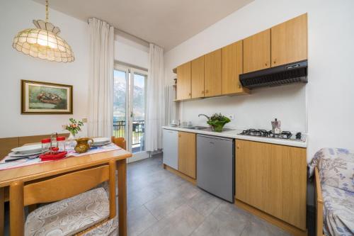 a kitchen with wooden cabinets and a table at Recidence EMILIO in Ledro