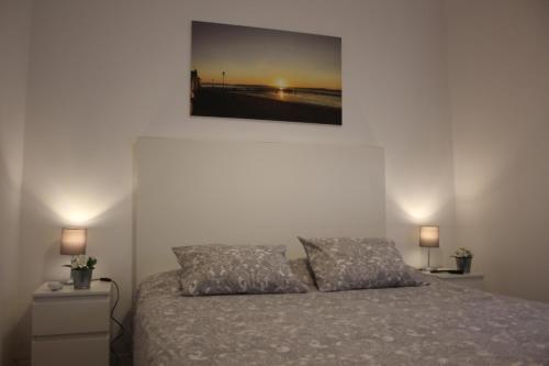 a bedroom with a bed with a picture on the wall at TangoSierraResidences in Alcochete