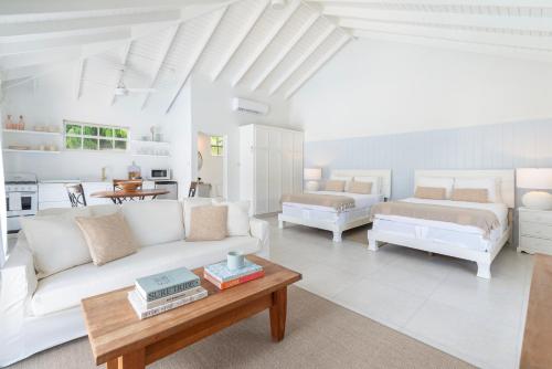 a living room with a white couch and a table at Gibbs Cottages in Saint Peter