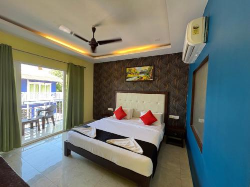 a bedroom with a bed with red pillows and a balcony at Sabbia Rossa Beach Resort in Arambol