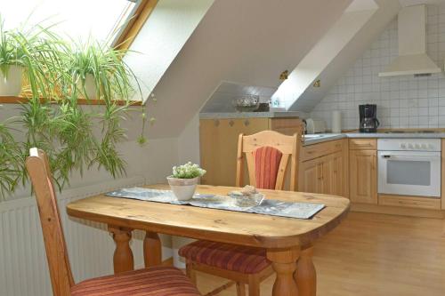 a kitchen with a wooden table and some plants at Ferienwohnung Sonnenberg, 25502 in Weener