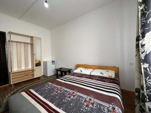 a bedroom with a large bed and a window at Guest House Arbat in Cholpon-Ata
