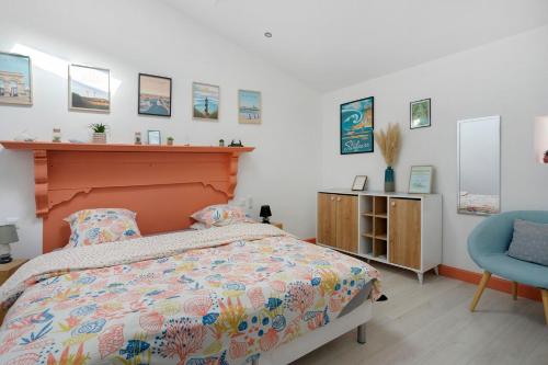 a bedroom with a bed and a blue chair at Gîte de la Barrière in Sainte-Gemme