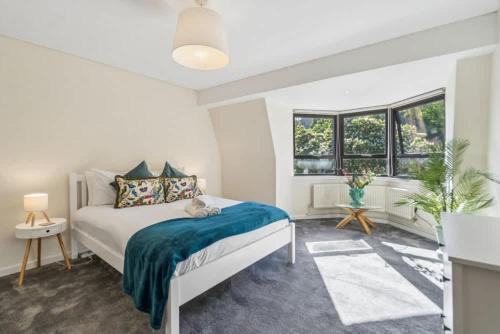 a white bedroom with a bed and a window at Windsor Castle Views - Spacious Flat - By Tempstay in Windsor