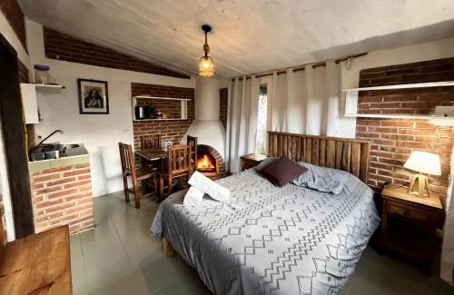 a bedroom with a bed and a kitchen and a table at La Misión Cabañas Chignahuapan in Chignahuapan