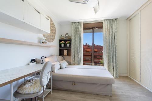a bedroom with a bed and a desk and a window at Veras Home in La Tejita