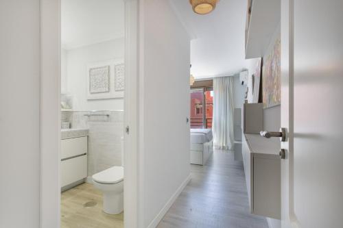 a white bathroom with a toilet and a sink at Veras Home in La Tejita
