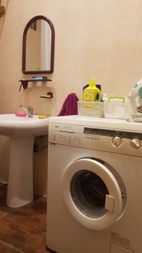 a bathroom with a washing machine and a sink at Dacha Pool and Grill in Karavan