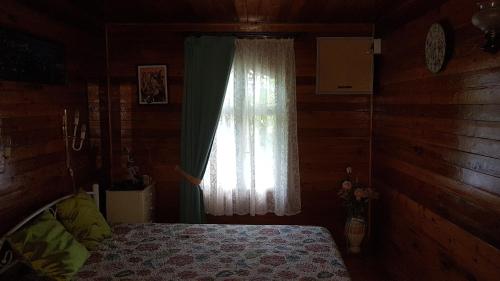 a bedroom with a bed and a window at Dacha Pool and Grill in Karavan