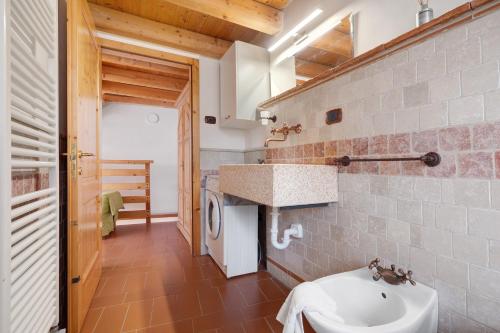 a bathroom with a sink and a washing machine at Casa Sole in Ceniga