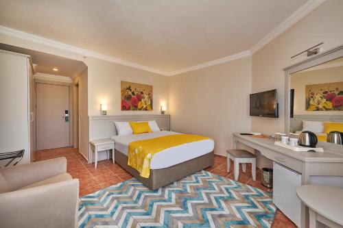 a hotel room with a bed and a desk at Fun Sun Smart Lurea Beach in Kemer