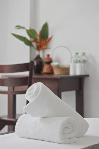 a pile of white towels sitting on a table at Mihira Gedara Apartments in Unawatuna