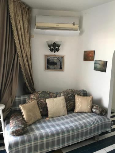a couch sitting in a living room with a window at Vue superbe in Port El Kantaoui