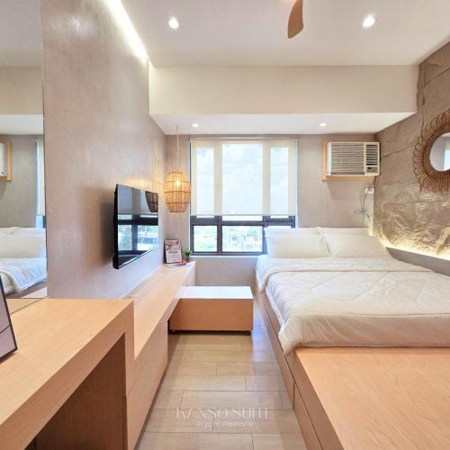 a hotel room with two beds and a tv at Studio with Free Pool Access & Night Swimming in Capitol Town in San Fernando
